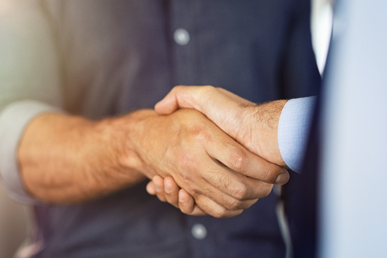 Two dealmakers shaking hands to close a transaction